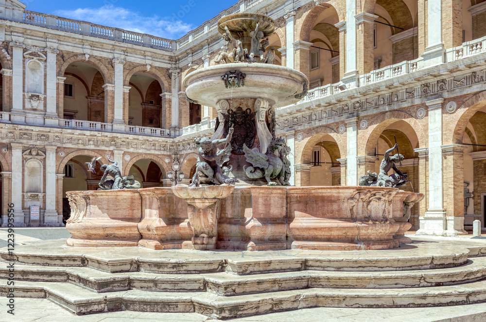Loreto, Marche, Italy- July 03, 2024: Fountain adorned with sculptures in the vibrant Cathedral Square of Loreto during a sunny day. Italian province of Ancona, Marche region.