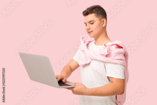 Teenage boy using laptop on...