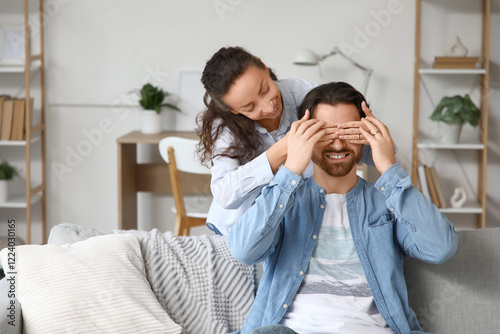 Happy wife covering her hus...