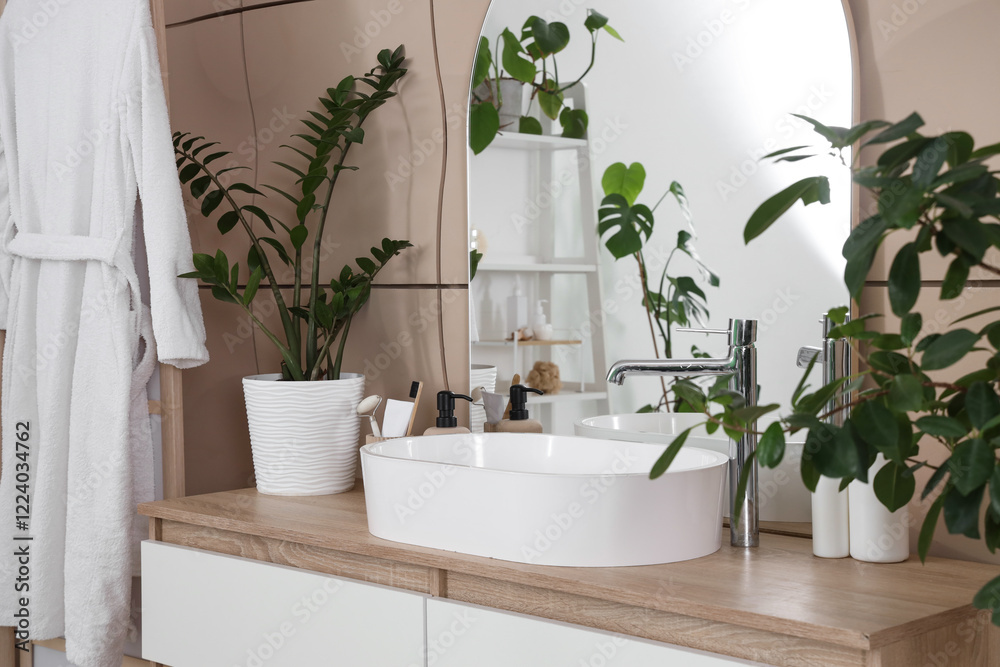 Fototapeta premium Sink with plants and mirror on drawers in bathroom