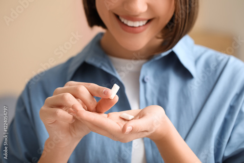 Fotografie Young woman with chewing gums at home, closeup