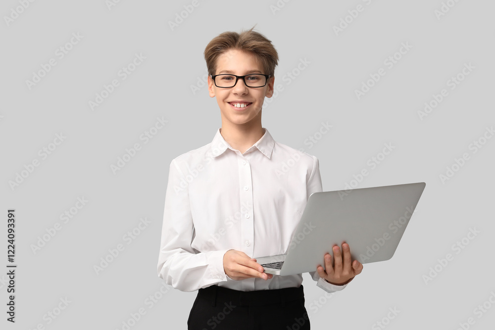 Teenage businessman with laptop on light background Teenage businessman with laptop on light background