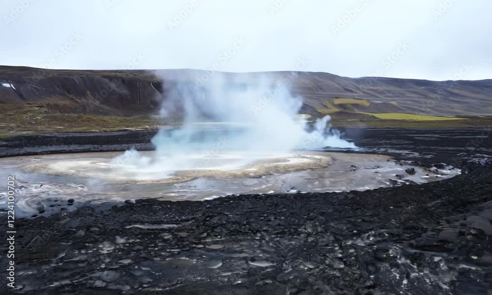 Aerial view of a geothermal area with steam rising from a hot spring surrounded by rocky terrain Aerial view of a geothermal area with steam rising from a hot spring surrounded by rocky terrain