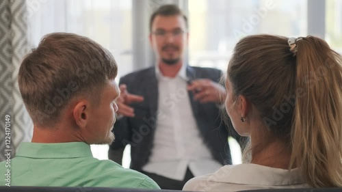 Selective focus on the family psychologist helping the couple seated on the couch, guiding them through the aftermath of stressful events and restoring emotional balance in their relationship.