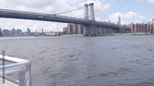 New York City skyline from ferry boat. Manhattan midtown highrise skyscrapers view from ferryboat. East river waterfront panorama, riverfront buildings architecture near water USA. Williamsburg Bridge