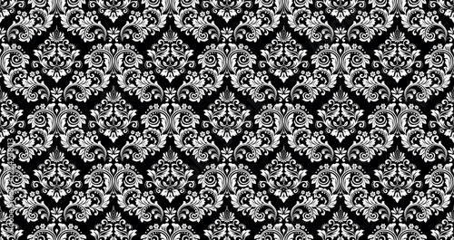 Wallpaper in the style of Baroque. White and black floral ornament. Seamless vector background. Graphic pattern for fabric, wallpaper, packaging. Ornate Damask flower illustration.