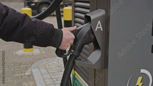 Wallpaper Mural Hand grabbing the plug of an electric vehicle parking station in slow motion Torontodigital.ca