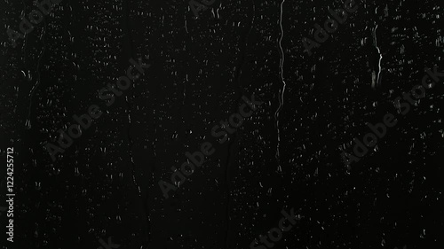 Closeup water rainfall, rain drops falling on window glass over black background