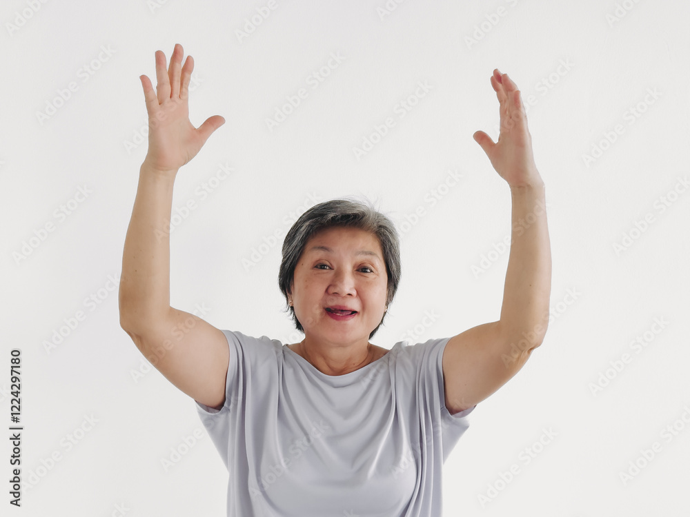 Asian elder woman feeling happy and grateful, spreading and raising hands up, smiling while standing isolated over white background wall. Asian elder woman feeling happy and grateful, spreading and raising hands up, smiling while standing isolated over white background wall.
