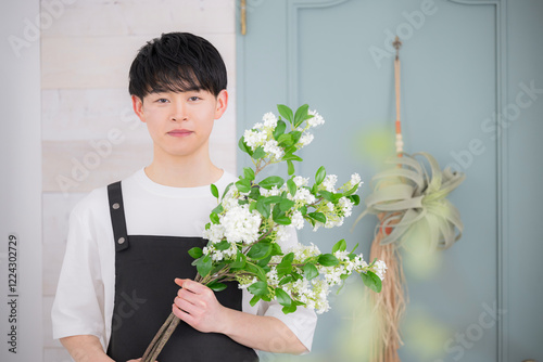 Young 20-something male working part-time or part time in a florist shop, looking into the camera Image of jobs and hiring