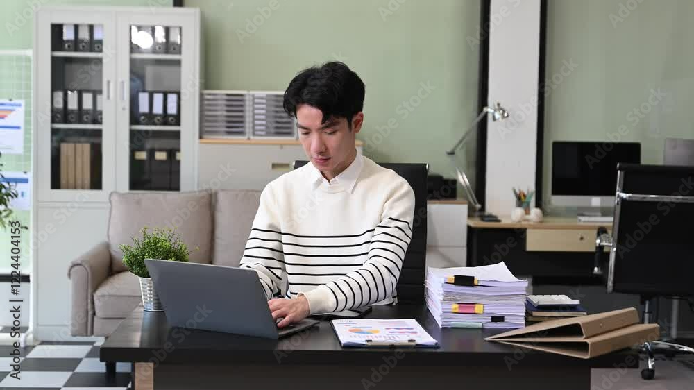 Young Businessman using laptop and tablet while sitting at her working place Young Businessman using laptop and tablet while sitting at her working place