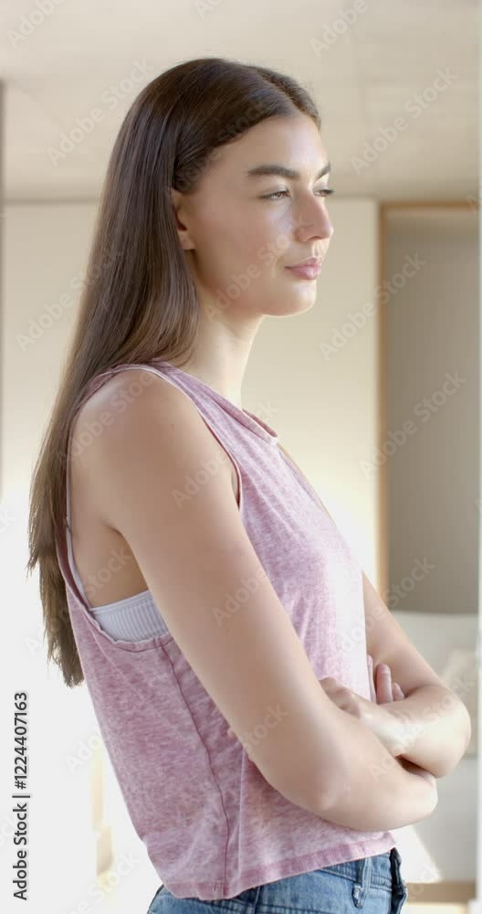 Vertical video: Teenage girl standing at home, looking at camera with relaxed expression Vertical video: Teenage girl standing at home, looking at camera with relaxed expression