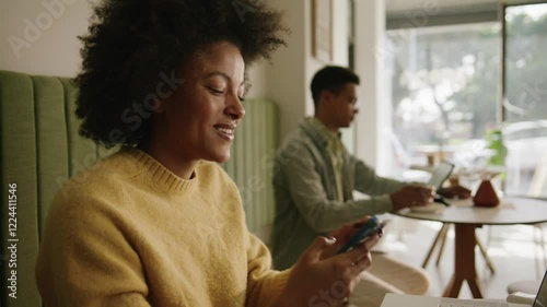 African American woman ending a business call and typing on her computer