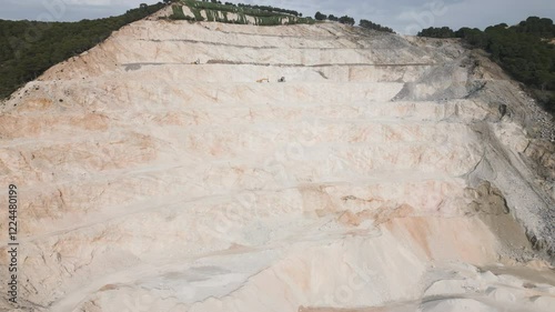 Massive mountain slope turned into quarry, aerial drone side fly view photo