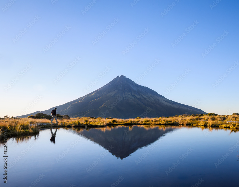 Man hiking the Pouakai circuit. Mt Taranaki under the clear blue sky. New Zealand.