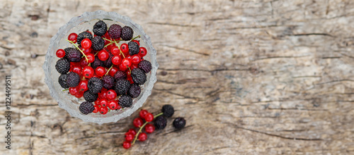 Obraz na płótnie Summer fresh berries blackberry and red currant in a bowl on rustic wooden table. Flat lay, copy space. w salonie
