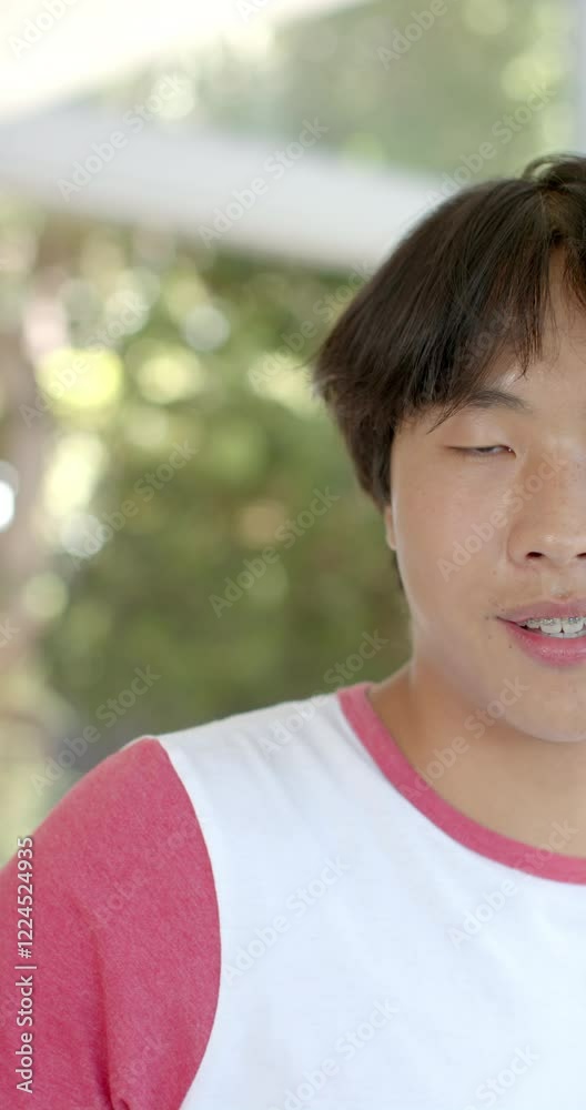 Vertical video: Smiling Asian teenage boy with braces wearing casual shirt at home, looking at camer Vertical video: Smiling Asian teenage boy with braces wearing casual shirt at home, looking at camer