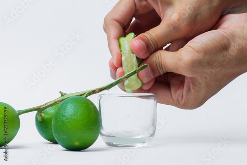 The Process of Squeezing Lime on isolated white background (Proses Memeras Jeruk Nipis Sumber Alami Kesegaran dan Manfaat Kesehatan dilatar belakang warna putih)