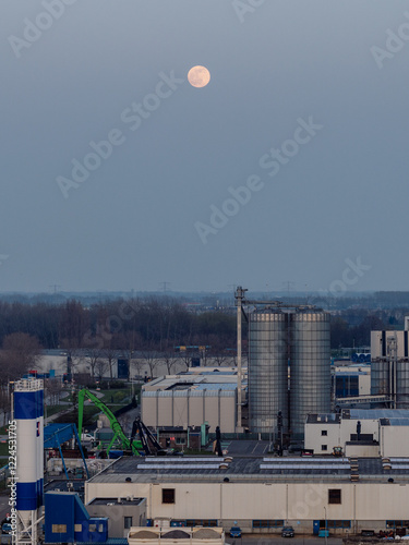 A full moon over an industrial site.