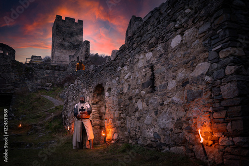 Mittelalterlicher wächter mit Schwert vor der Burg im Abendrot photo