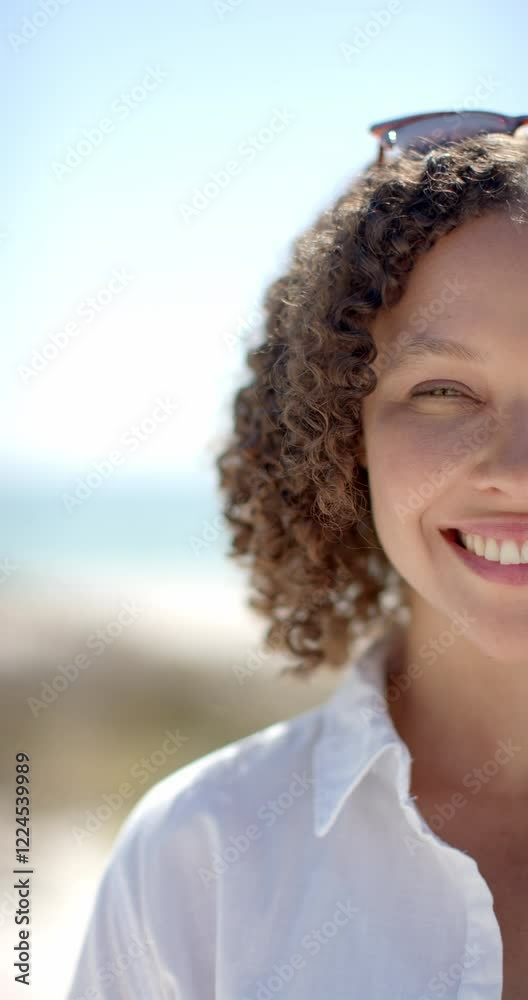 Vertical video: Smiling woman enjoying sunny day at beach, wearing white shirt Vertical video: Smiling woman enjoying sunny day at beach, wearing white shirt