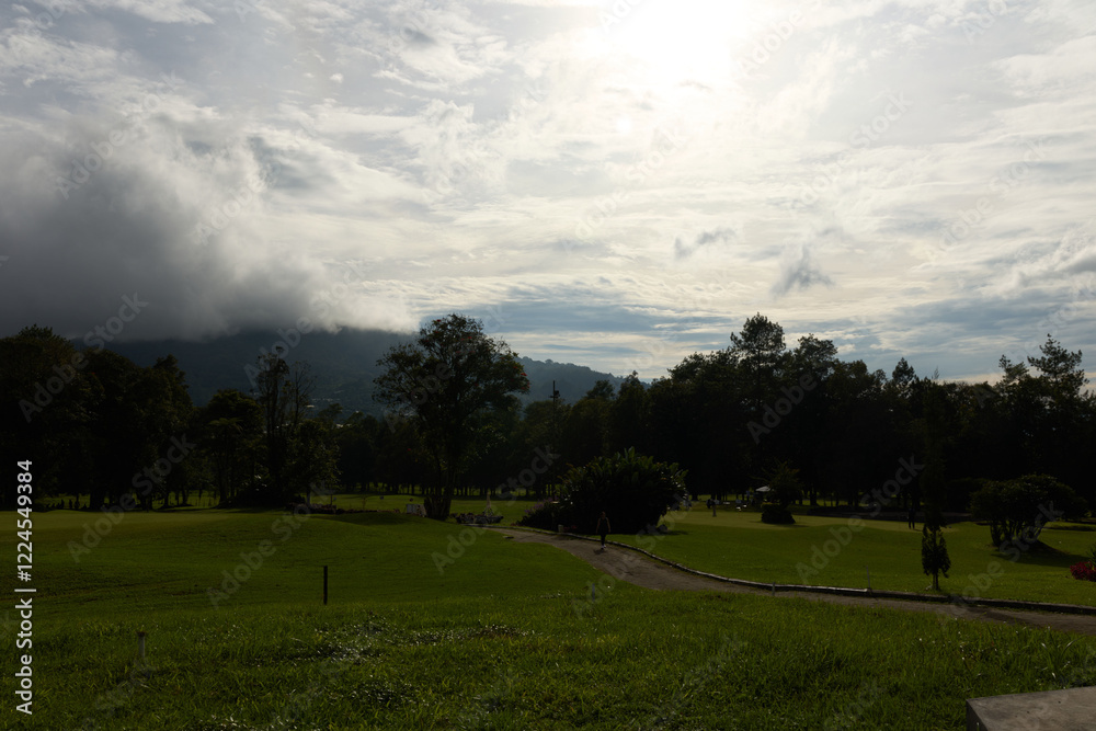 Serene landscape of a lush green golf course under a cloudy sky, perfect for relaxation and outdoor activities Serene landscape of a lush green golf course under a cloudy sky, perfect for relaxation and outdoor activities