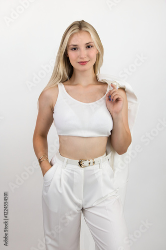 Portrait of a beautiful and smiling young woman in a white top and trousers