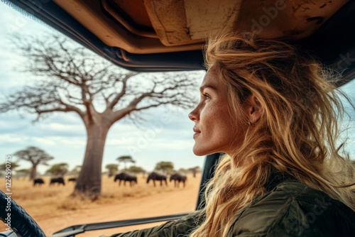 Wallpaper Mural Woman in safari vehicle observing herd of wild animals surrounded by baobab trees in savannah. Female tourist driving car in national park Torontodigital.ca