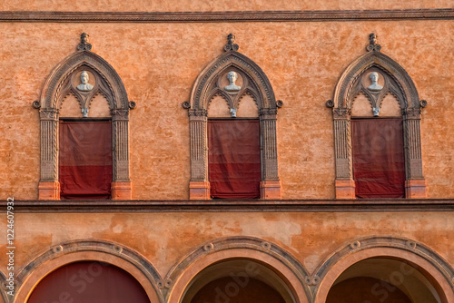 Close up of facade of historic building with Gothic-style architectural details, arched windows, bust sculptures on Piazza Santo Stefano in Bologna old town, Emilia Romagna, Italy photo