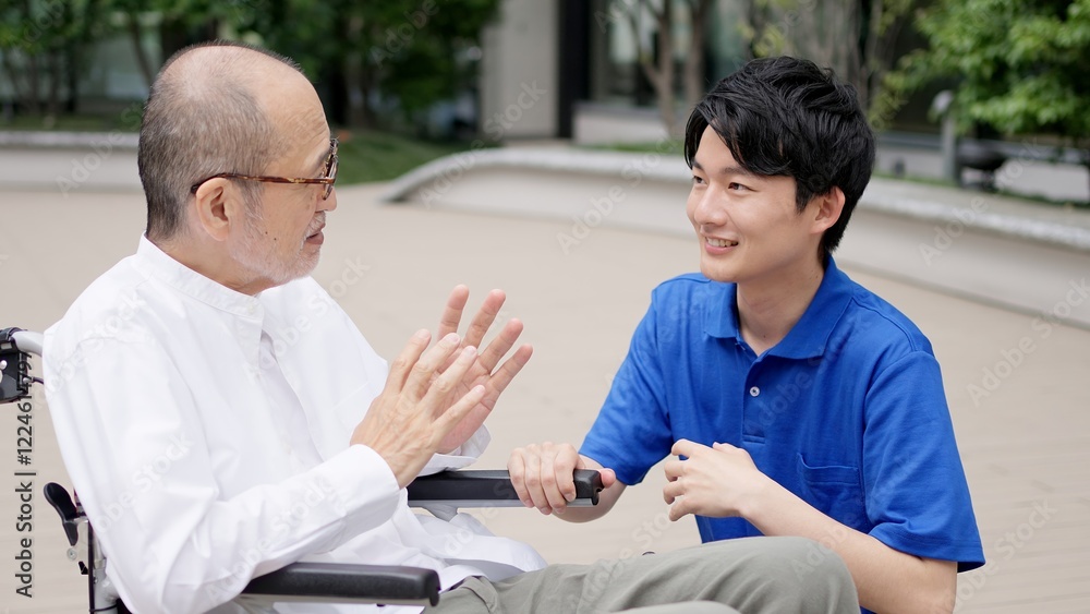Obraz premium 車椅子の高齢者と話をする介護士