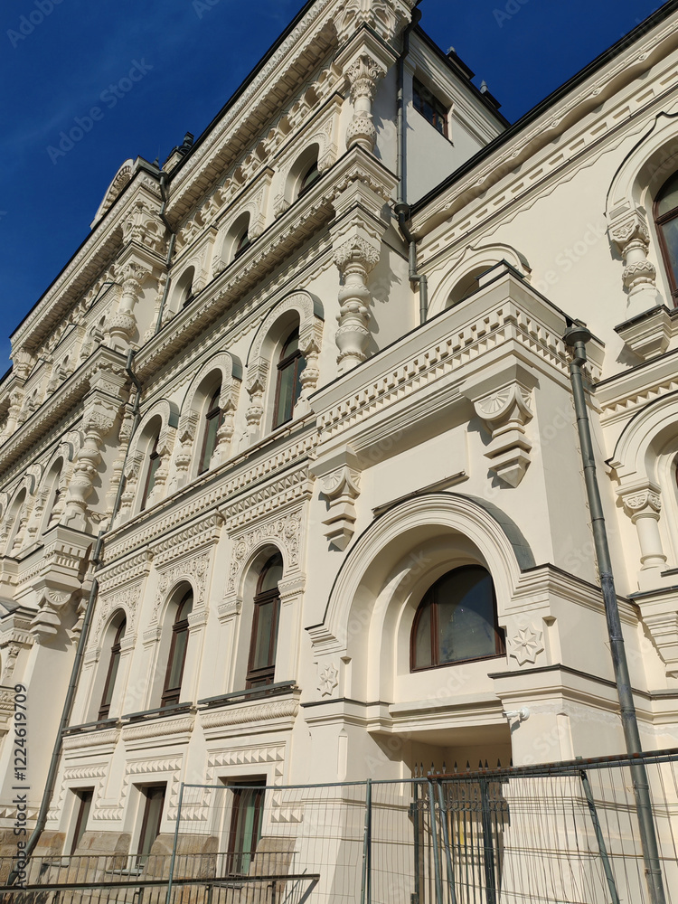 A grand facade featuring intricate carvings, tall arched windows, and contemporary railings. The composition emphasizes the harmony of traditional craftsmanship and modern infrastructure. A grand facade featuring intricate carvings, tall arched windows, and contemporary railings. The composition emphasizes the harmony of traditional craftsmanship and modern infrastructure.