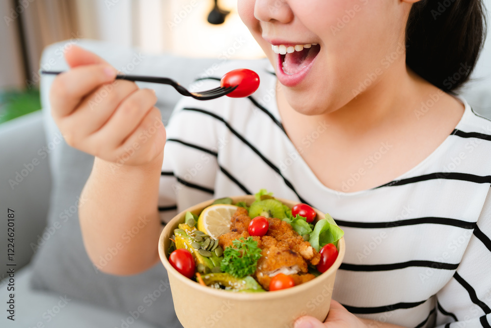 Beautiful plump woman holding a salad bowl and eating a salad in the bowl. Beautiful plump woman holding a salad bowl and eating a salad in the bowl.