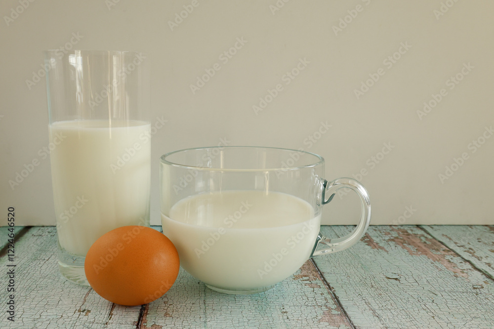 Eggs and milk on rustic wooden table, photographed from a side view. Eggs and milk on rustic wooden table, photographed from a side view.