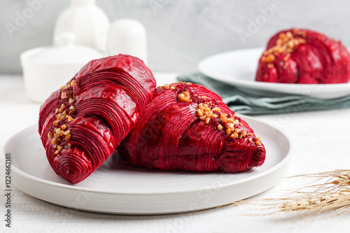 Red velvet croissant on a white plate.