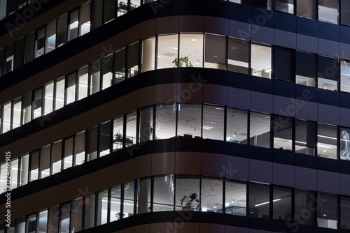 Obraz na płótnie lit windows of a modern office building in the evening w salonie