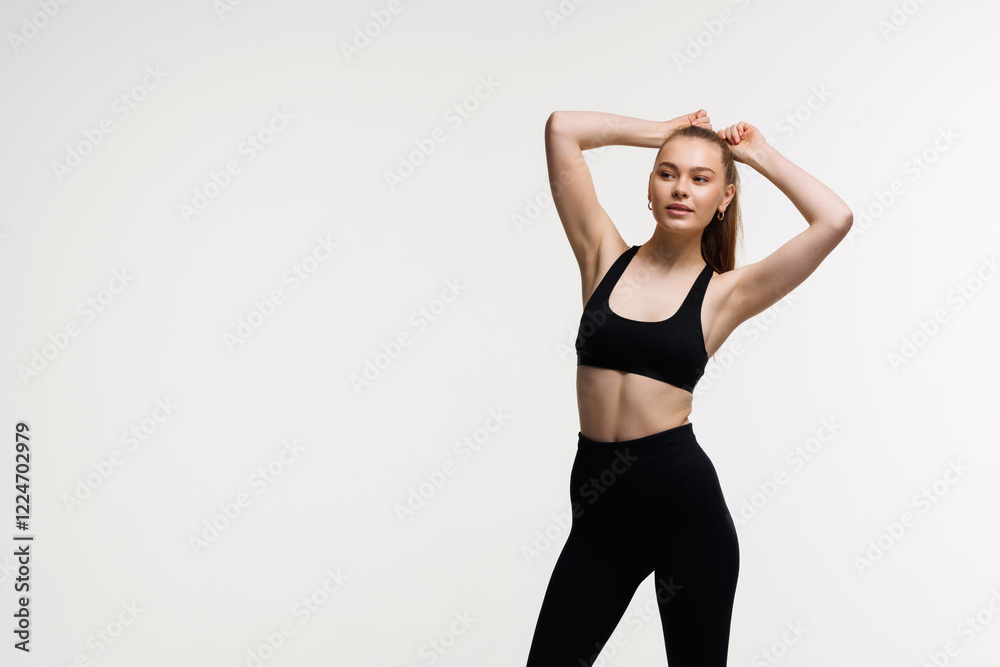 Sporty slim woman with ponytail enjoys workout exercise in sport wear on white background Sporty slim woman with ponytail enjoys workout exercise in sport wear on white background