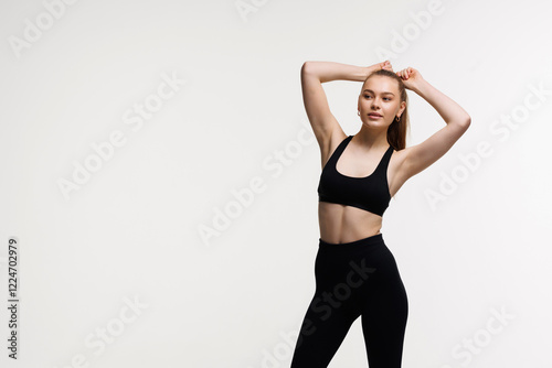 Sporty slim woman with ponytail enjoys workout exercise in sport wear on white background