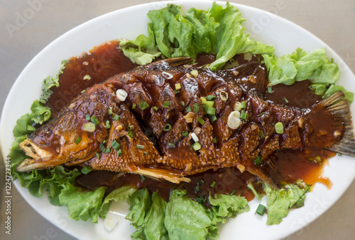 Crispy fried fish with sweet and sour sauce, a unique Chinese dish. photo