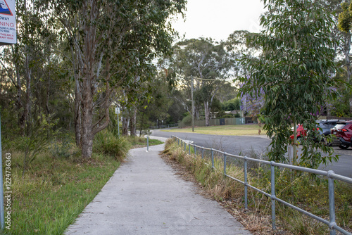 Photography Scenic pathway lined with vibrant pink-red flowers and lush greenery, leading through an international peace park in Western Sydney, Australia