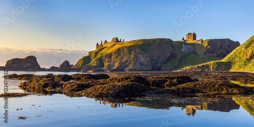 Dunnottar Castle bathed in morning sunlight, taken from Castle Haven near Stonehaven in Aberdeenshire. photo