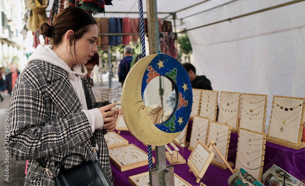 Young woman choosing jewelry at el rastro flea market in madrid