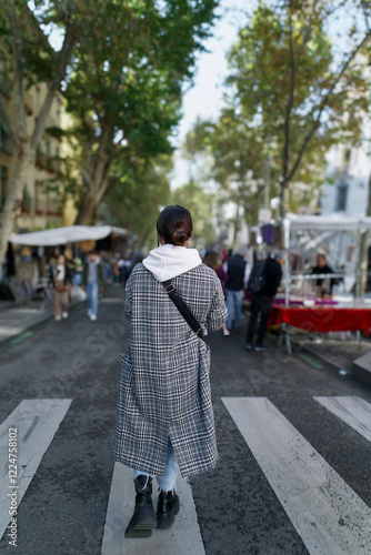 Woman crossing the street at el rastro flea market in madrid, spain