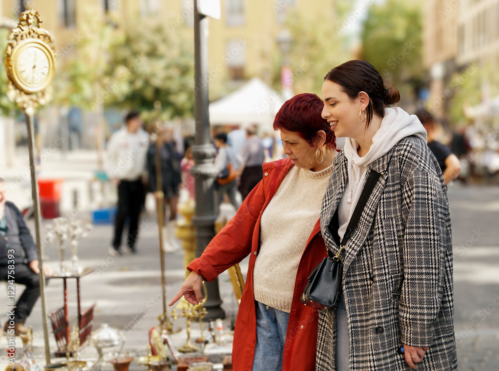 Women exploring vintage objects at el rastro flea market in madrid