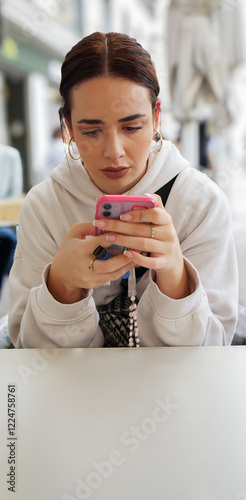Obraz na płótnie Young woman using smartphone and holding electronic cigarette at outdoor cafe w salonie