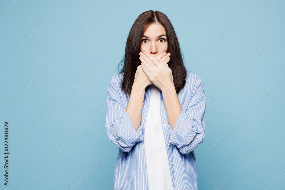 Young sad shocked surprised Caucasian woman she wearing shirt casual clothes cover mouth with hand look camera isolated on plain pastel light blue cyan background studio portrait. Lifestyle concept. Young sad shocked surprised Caucasian woman she wearing shirt casual clothes cover mouth with hand look camera isolated on plain pastel light blue cyan background studio portrait. Lifestyle concept.