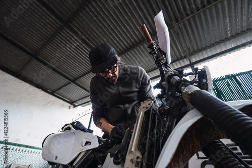 Obraz na płótnie Hombre moreno con gafas poniendo a punto moto de cross para usar en el campo w salonie