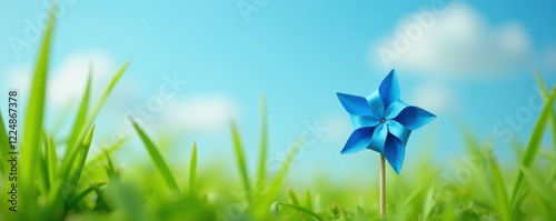 Tiny blue paper pinwheel nestled among tall grasses, sky, natural