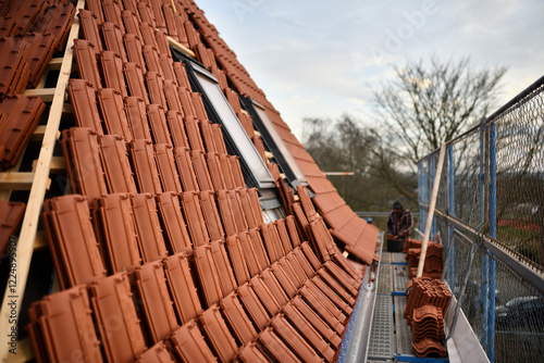 Dachdecker baut Dachfenster in rote Dachziegel Dächer ein. Dachdeckung neu Steildach