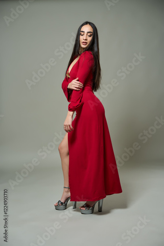 Young woman in red dress on gray background