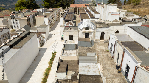 Fototapeta Naklejka Na Ścianę i Meble -  Aerial view of a small Christian Catholic cemetery. The streets between the chapels of the deceased are empty.